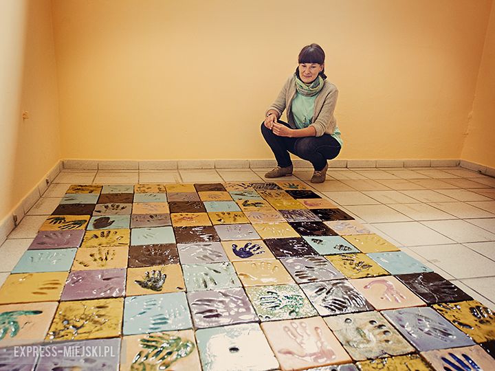  Mozaika z odciśniętych w glinianych kaflach dłoni mieszkańców 