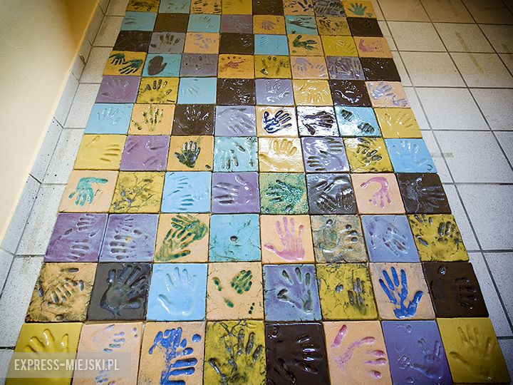  Mozaika z odciśniętych w glinianych kaflach dłoni mieszkańców 