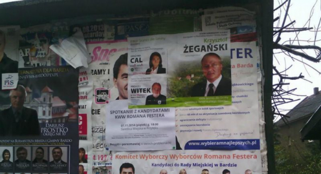 Plakaty wyborcze kandydata Romana Festera zaklejone przez materiał wyborczy Krzysztofa Żegańskiego - tablica informacyjna w Przyłęku
