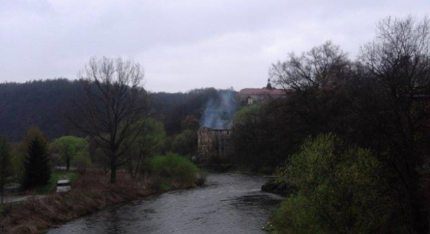 Pożar starego młyna widziany z zabytkowego mostu kamiennego