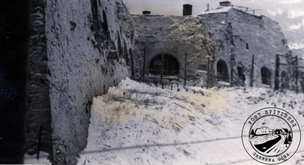 Na zdjęciu Fort Spitzberg-Ostróg w czasie II wojny światowej - widoczne opisywane przez między innymi Jędrzeja Giertycha płoty z drutów kolczastych. Trudno powiedzieć, czy zdjęcie pochodzi z czasów gdy w forcie był oflag (1939-1941) czy stalag dla rosyjskich jeńców (po 1942 roku)