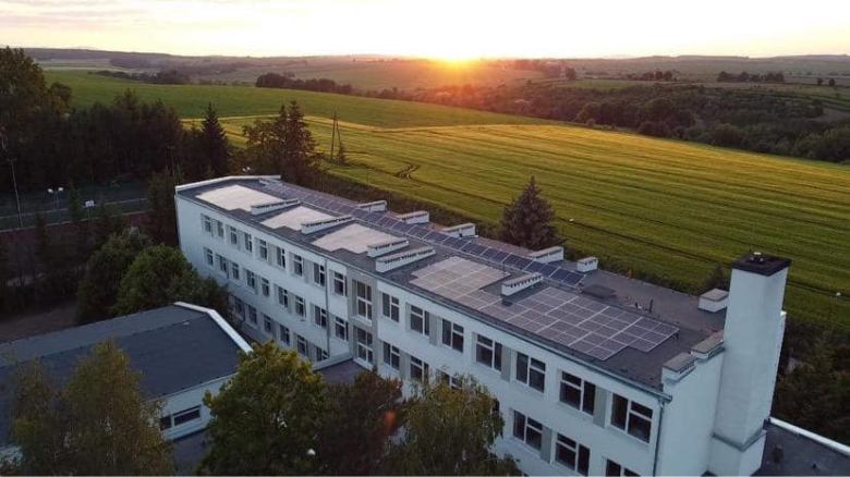 Budynek Szkoły Podstawowej w Henrykowie po termomodernizacji z instalacją wytwarzającą energię elektryczną na dachu budynku głównego