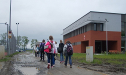 Nowoczesna szkoła z polną drogą dojazdową
