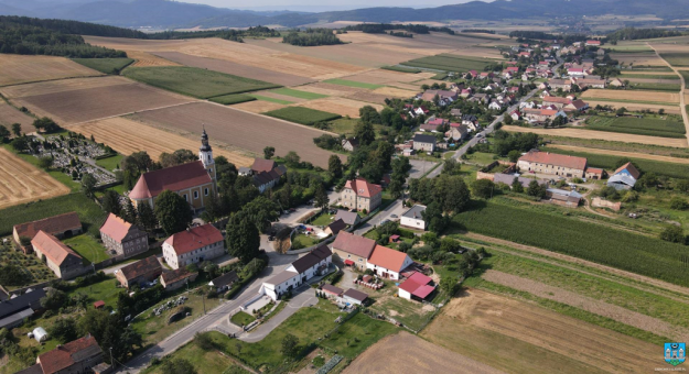 Wykonano asfaltową nawierzchnię wraz z umocnieniem poboczy i wykonaniem zjazdów